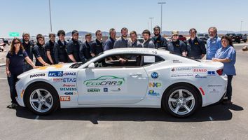 The car that competed in the EcoCAR 3 Challenge in Year 2 and the team standing behind it